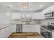 Updated kitchen with stainless steel appliances, white cabinetry, marble countertops, and tiled backsplash at 357 Hearthstone Ter, Port Orange, FL 32127