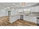 Well-lit kitchen featuring stainless steel appliances, white cabinets, marble countertops, and wood-look flooring at 357 Hearthstone Ter, Port Orange, FL 32127