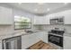 Modern kitchen featuring stainless steel appliances, white cabinets, and elegant marble countertops at 357 Hearthstone Ter, Port Orange, FL 32127