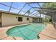 Inviting pool with screened enclosure surrounded by lush landscaping and a privacy fence at 357 Hearthstone Ter, Port Orange, FL 32127