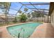 Inviting pool with screened enclosure surrounded by lush landscaping and a privacy fence at 357 Hearthstone Ter, Port Orange, FL 32127