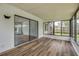 Bright sunroom featuring wood-look flooring, large windows, and a sliding glass door to bring the outdoors in at 357 Hearthstone Ter, Port Orange, FL 32127