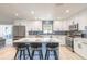 Modern kitchen features stainless steel appliances, white cabinets, blue backsplash, and a kitchen island with seating at 3626 Donna St, Port Orange, FL 32129