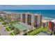 An aerial view showcasing a beachfront condominium with tennis courts and manicured landscaping at 4139 S Atlantic Ave # B508, New Smyrna Beach, FL 32169