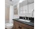 This bathroom features a vanity with dark countertop and a shower with white curtain at 4139 S Atlantic Ave # B508, New Smyrna Beach, FL 32169