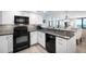 Well-maintained kitchen with white cabinets, granite countertops, and modern black appliances at 4139 S Atlantic Ave # B508, New Smyrna Beach, FL 32169