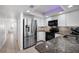 Modern kitchen featuring stainless steel appliances, granite countertops, and white cabinets at 4139 S Atlantic Ave # B508, New Smyrna Beach, FL 32169