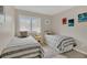Comfortable bedroom featuring two twin beds, natural lighting, and beach themed art at 4403 Sea Mist Dr # 109, New Smyrna Beach, FL 32169