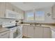 Bright kitchen features white appliances, ample cabinet space, and natural light from the window at 4403 Sea Mist Dr # 109, New Smyrna Beach, FL 32169