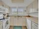 Bright kitchen featuring white cabinets, countertops, sink, and appliances with a window view at 4403 Sea Mist Dr # 109, New Smyrna Beach, FL 32169