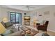 Comfortable living room featuring a sofa, armchairs, TV, and a glass door to the outdoors at 4403 Sea Mist Dr # 109, New Smyrna Beach, FL 32169
