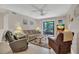 Inviting living room with cozy seating, ceiling fan, TV, and sliding glass doors to the outside at 4403 Sea Mist Dr # 109, New Smyrna Beach, FL 32169