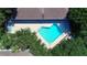 Aerial view of the community pool area, surrounded by lush greenery and featuring lounge chairs for relaxation at 4403 Sea Mist Dr # 109, New Smyrna Beach, FL 32169