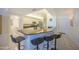 A kitchen island with a bar and seating sits next to modern, stainless appliances in an updated kitchen at 4555 S Atlantic Ave # 4405, Ponce Inlet, FL 32127