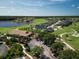 Aerial view of the neighborhood, showcasing houses, a golf course, and a lake at 461 Luna Bella Ln, New Smyrna Beach, FL 32168