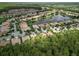 Aerial view of homes nestled around a lake with lush greenery, showcasing the tranquil community setting at 461 Luna Bella Ln, New Smyrna Beach, FL 32168