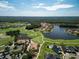 Expansive aerial view of golf community with homes surrounding a lake and golf course at 461 Luna Bella Ln, New Smyrna Beach, FL 32168