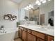 Bright bathroom showcasing double vanity, soaking tub, and large mirror at 461 Luna Bella Ln, New Smyrna Beach, FL 32168