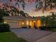 Charming single-story home featuring a beautiful brick driveway and lush landscaping under a colorful sunset sky at 461 Luna Bella Ln, New Smyrna Beach, FL 32168