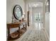 Entrance with a round mirror over a wooden table, showing the home's architectural details and decor at 461 Luna Bella Ln, New Smyrna Beach, FL 32168