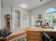 Functional office space featuring a wooden desk, arched windows, and a comfortable chair at 461 Luna Bella Ln, New Smyrna Beach, FL 32168