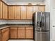 Kitchen with stainless steel refrigerator, wood cabinets, and granite countertops at 461 Luna Bella Ln, New Smyrna Beach, FL 32168