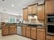 Kitchen with tile floors, granite countertops, wood cabinets, and stainless steel appliances at 461 Luna Bella Ln, New Smyrna Beach, FL 32168