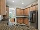 Kitchen with granite countertops, wood cabinets, stainless steel appliances and views into the office at 461 Luna Bella Ln, New Smyrna Beach, FL 32168