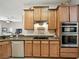 Kitchen featuring granite countertops, wood cabinets, tile floors, and stainless steel appliances at 461 Luna Bella Ln, New Smyrna Beach, FL 32168