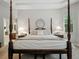 Main bedroom with four-poster bed and tray ceiling at 461 Luna Bella Ln, New Smyrna Beach, FL 32168
