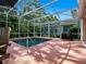 Screened-in pool area with table, chairs, and outdoor grill at 461 Luna Bella Ln, New Smyrna Beach, FL 32168