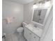 Cozy half-bath featuring a white vanity, toilet, and decorative wallpaper at 4777 S Atlantic Ave # B2, Port Orange, FL 32127