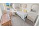 Cozy bedroom with neutral walls and flooring, a woven desk, and bright natural light from a large window at 4777 S Atlantic Ave # B2, Port Orange, FL 32127