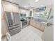 Well-lit kitchen featuring stainless steel appliances, white cabinets, and tile flooring at 4777 S Atlantic Ave # B2, Port Orange, FL 32127