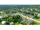 An aerial view showcases a home with a screened pool and lush greenery in a peaceful neighborhood setting at 505 Sandale Ct, Deland, FL 32724