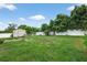 Spacious backyard featuring a well-maintained lawn, a shed, and bordered by a white vinyl fence for privacy at 505 Sandale Ct, Deland, FL 32724