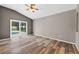 A bedroom features wood floors and sliding glass doors with views of the screened-in lanai and pool at 505 Sandale Ct, Deland, FL 32724