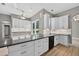 An oversized kitchen boasts white cabinets, stainless steel appliances, a breakfast bar, and granite countertops at 505 Sandale Ct, Deland, FL 32724