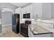 The modern kitchen showcases black stainless steel appliances, white cabinets, and gray countertops at 505 Sandale Ct, Deland, FL 32724