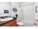 Bright bathroom features a shower-tub combo, neutral tile, and a lovely vanity with a dark countertop at 518 Safe Harbor Dr, Edgewater, FL 32141