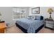Comfortable bedroom with a patterned blue comforter, a side table, a window with blinds, and neutral carpeting at 518 Safe Harbor Dr, Edgewater, FL 32141