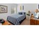 Stylish bedroom with a striped bedspread, nautical decor, a window, side table, and a bright, airy feel at 518 Safe Harbor Dr, Edgewater, FL 32141