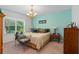 Serene bedroom featuring a queen bed with decorative pillows, a chandelier, and ample natural light from the window at 518 Safe Harbor Dr, Edgewater, FL 32141