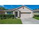 Charming home featuring a well-maintained lawn, inviting entrance, and a two-car garage under a sunny, blue sky at 518 Safe Harbor Dr, Edgewater, FL 32141