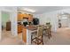 Functional kitchen featuring a central island with seating, wooden cabinetry, and essential appliances under bright lighting at 518 Safe Harbor Dr, Edgewater, FL 32141