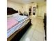 Bedroom with tile floor, a large bed, and a small view of the bathroom at 520 Aeolian Dr, New Smyrna Beach, FL 32168
