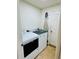 A functional laundry room featuring a washer, dryer, ironing board, and white walls and door at 520 Aeolian Dr, New Smyrna Beach, FL 32168