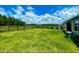 Well-maintained backyard with green lawn, fenced perimeter and view of trees and greenery at 5263 Bear Corn Run, Port Orange, FL 32128