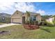 Charming single-story home featuring a well-maintained lawn, tropical foliage, and an attached two-car garage at 5263 Bear Corn Run, Port Orange, FL 32128
