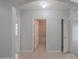 Arched doorway from the hallway that provides view of the white tiled bathroom and additional rooms at 5263 Bear Corn Run, Port Orange, FL 32128